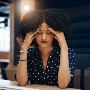 woman feeling unwell, with her hand on her head